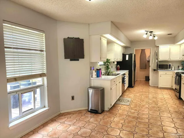 a large white kitchen with a large window