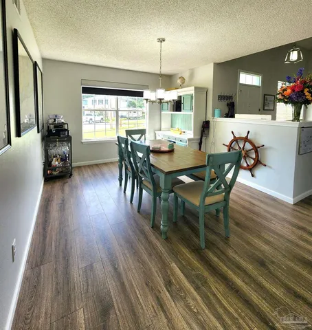 a view of a a dining room with furniture window and wooden floor