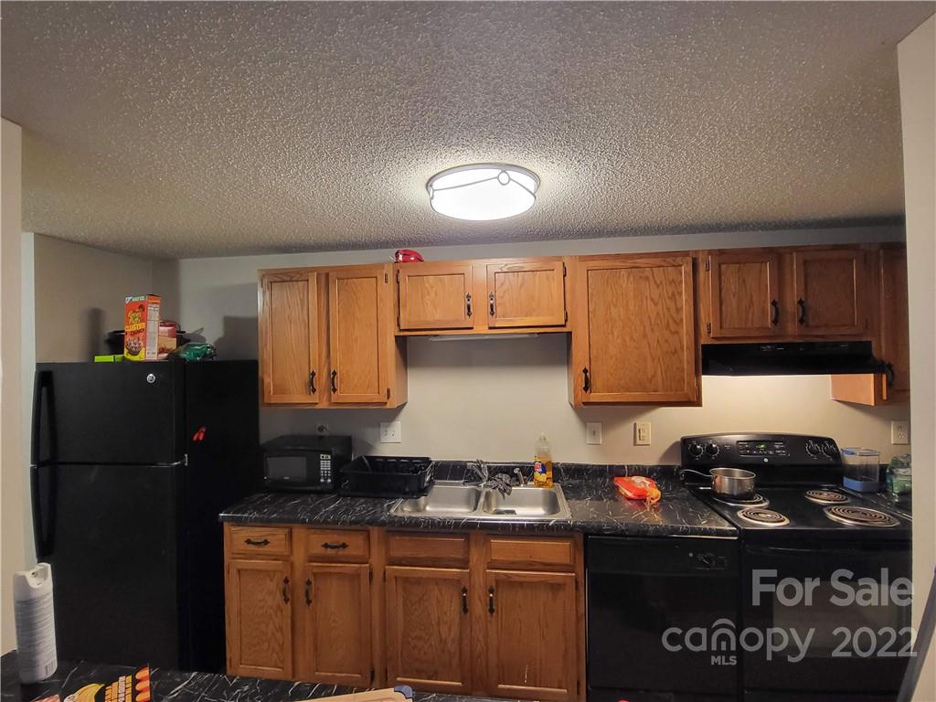 9405 Old Concord Road, Unit D Charlotte, NC 28213 - Photo 6 of 17 a kitchen with a sink a stove and refrigerator