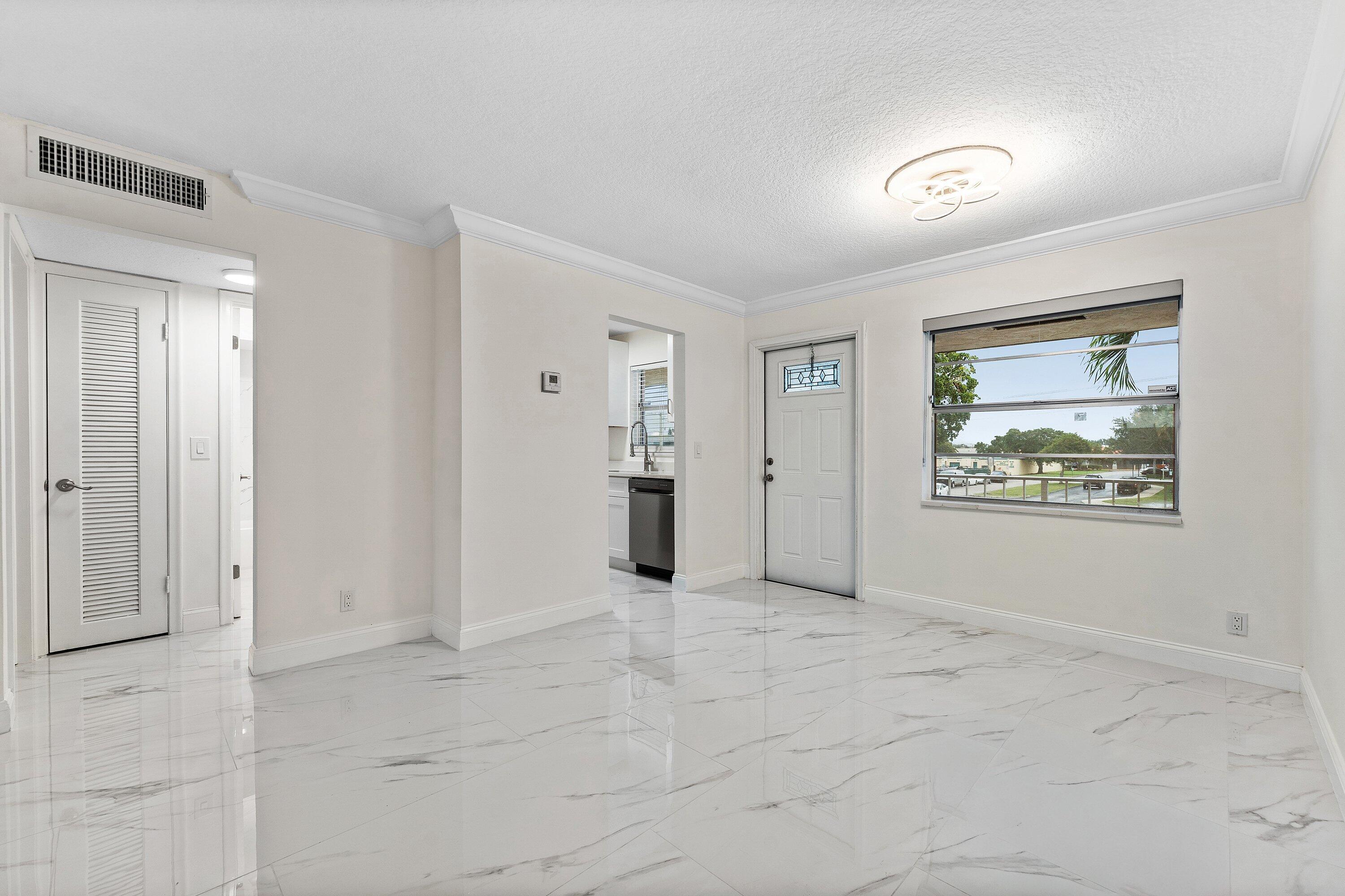 9911 Sandalfoot Boulevard, Unit 113 Boca Raton, FL 33428 - Photo 11 of 19 an empty room with windows