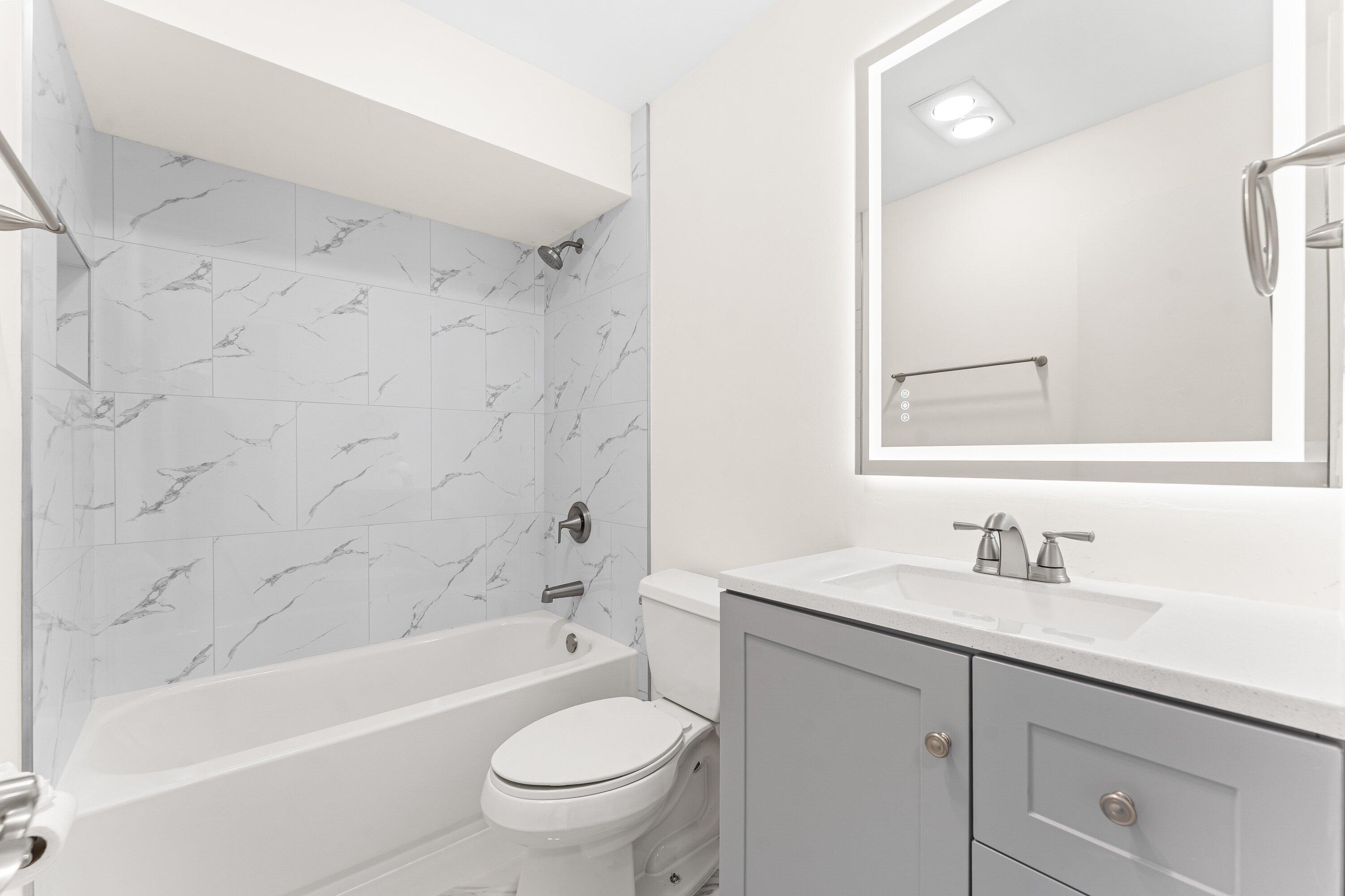 9911 Sandalfoot Boulevard, Unit 113 Boca Raton, FL 33428 - Photo 12 of 19 a bathroom with a sink toilet and bathtub