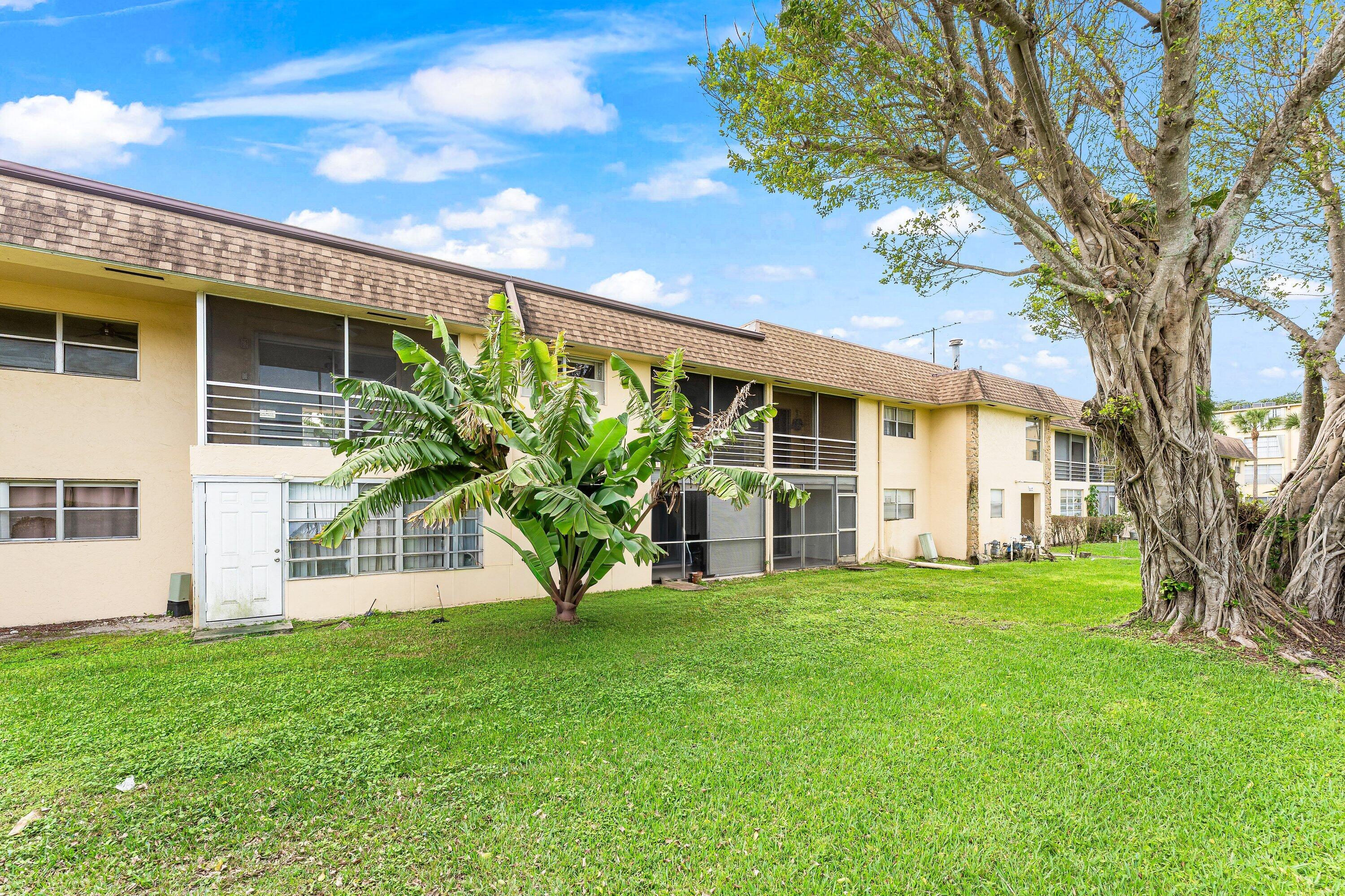 9911 Sandalfoot Boulevard, Unit 113 Boca Raton, FL 33428 - Photo 17 of 19 a view of a house with a yard