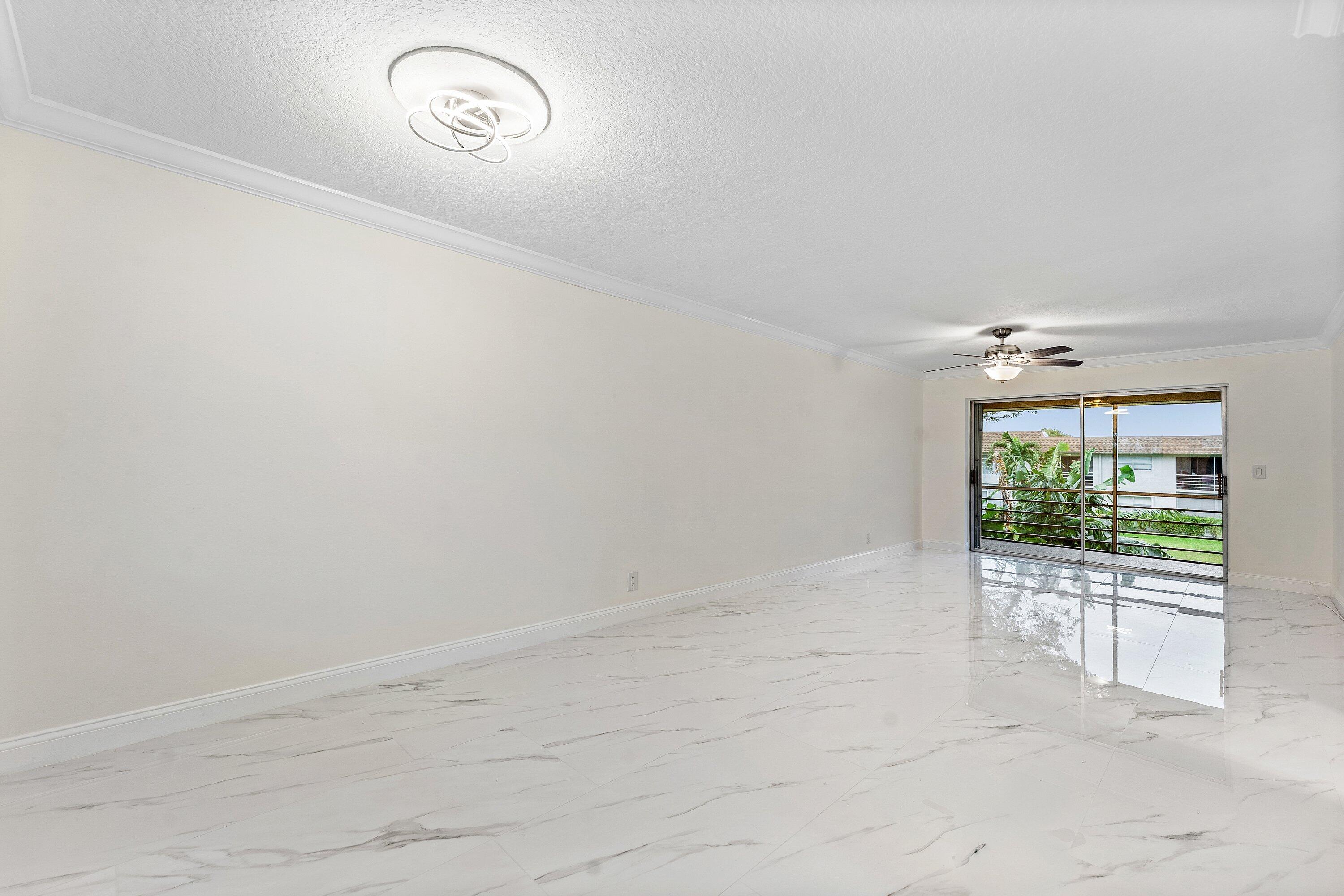 9911 Sandalfoot Boulevard, Unit 113 Boca Raton, FL 33428 - Photo 6 of 19 an empty room with windows