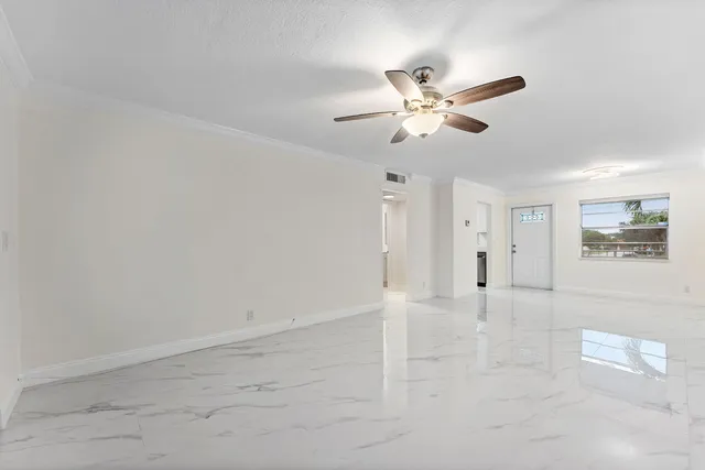 an empty room with fan and windows