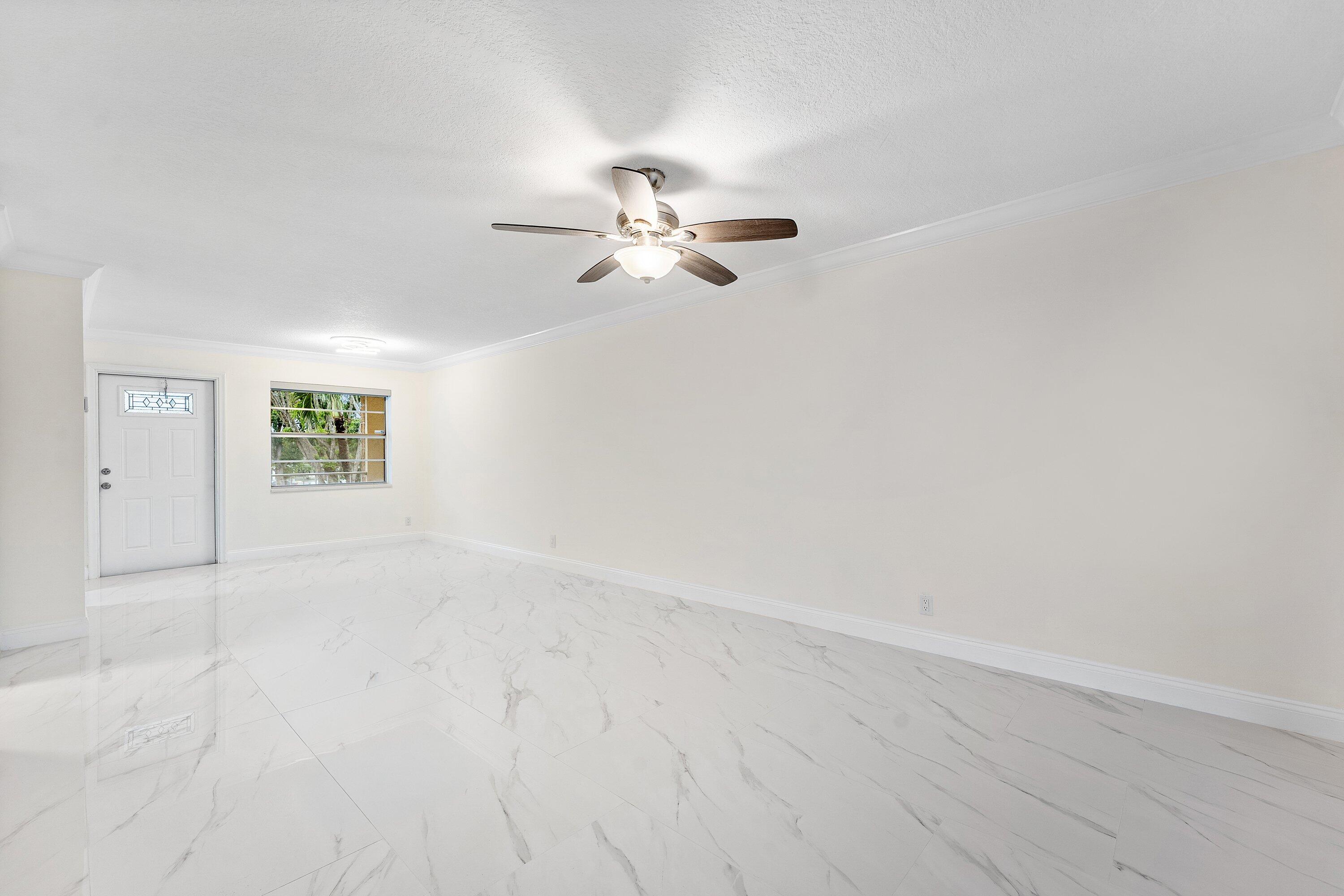 9911 Sandalfoot Boulevard, Unit 113 Boca Raton, FL 33428 - Photo 10 of 19 an empty room with fan and windows