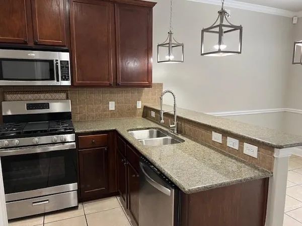 a kitchen with stainless steel appliances granite countertop a sink stove and microwave
