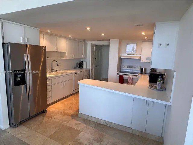 a kitchen with kitchen island stainless steel appliances a refrigerator and a sink