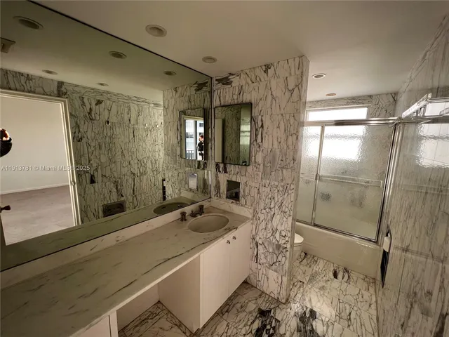 a bathroom with a double vanity sink a toilet a mirror and shower