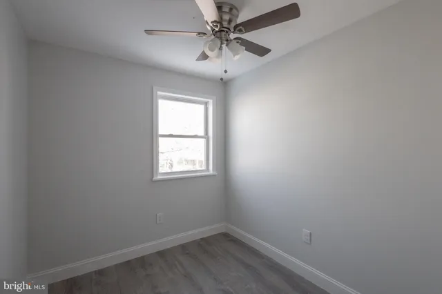 an empty room with a window and a fan