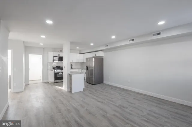 a view of kitchen with refrigerator and wooden floor