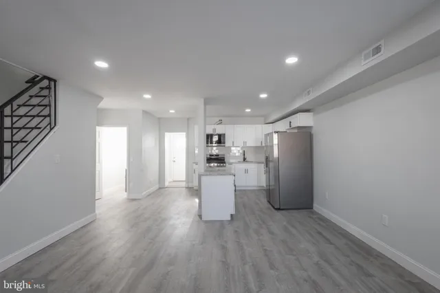 a view of a kitchen with a sink and wooden floor