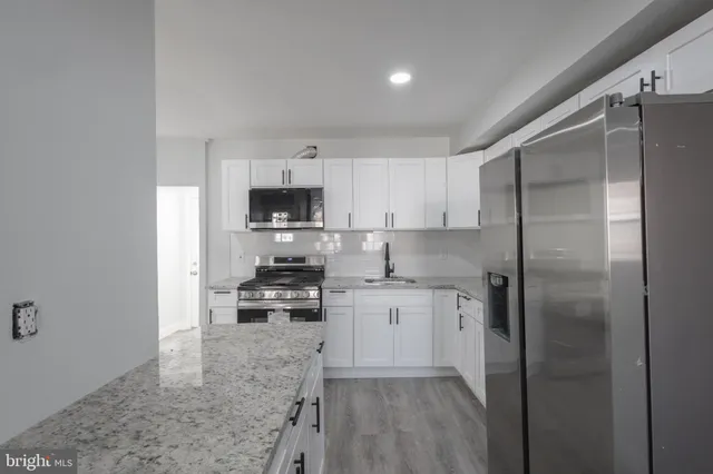 a kitchen with a refrigerator a sink and cabinets