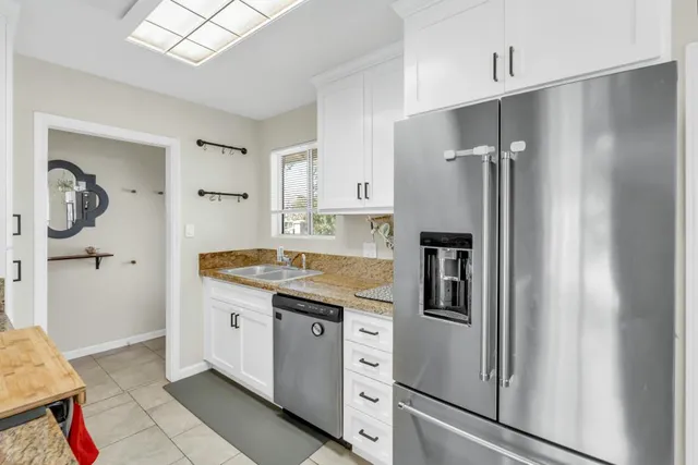a kitchen with stainless steel appliances granite countertop a refrigerator and a sink