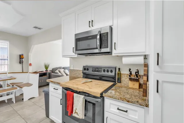 a kitchen with stainless steel appliances granite countertop a sink stove and cabinets