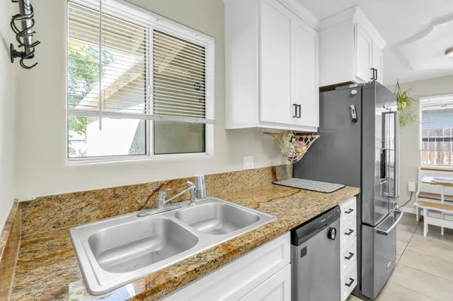 a kitchen that has a sink a stove and a refrigerator