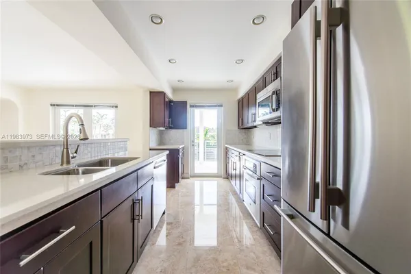 a kitchen with stainless steel appliances granite countertop a refrigerator and a sink