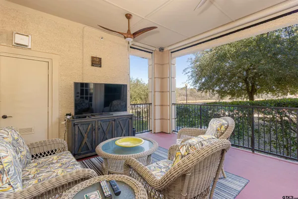 a living room with furniture a flat screen tv and a large window