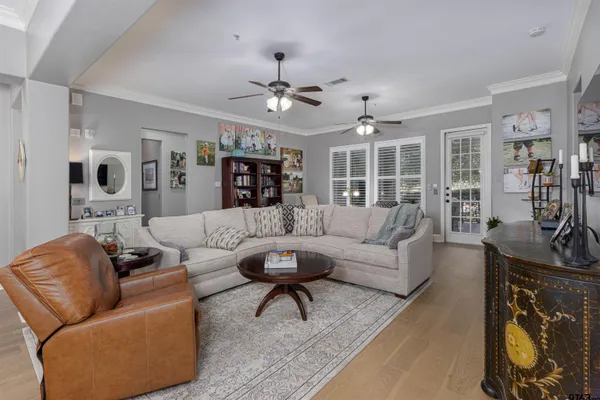 a living room with furniture a chandelier and a flat screen tv
