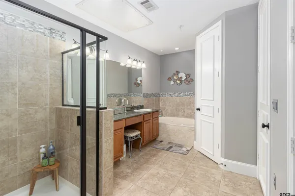 a bathroom with a granite countertop sink mirror and a bathtub