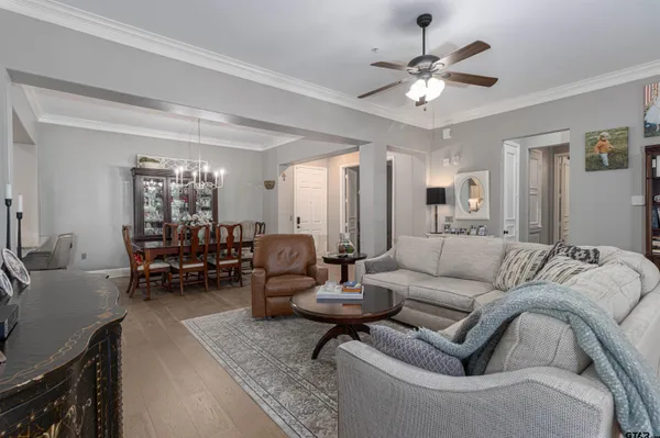 a living room with furniture white walls and a chandelier