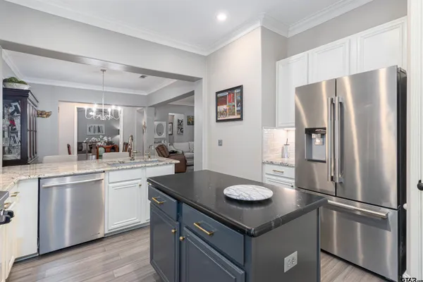 a kitchen with kitchen island a sink stove and refrigerator