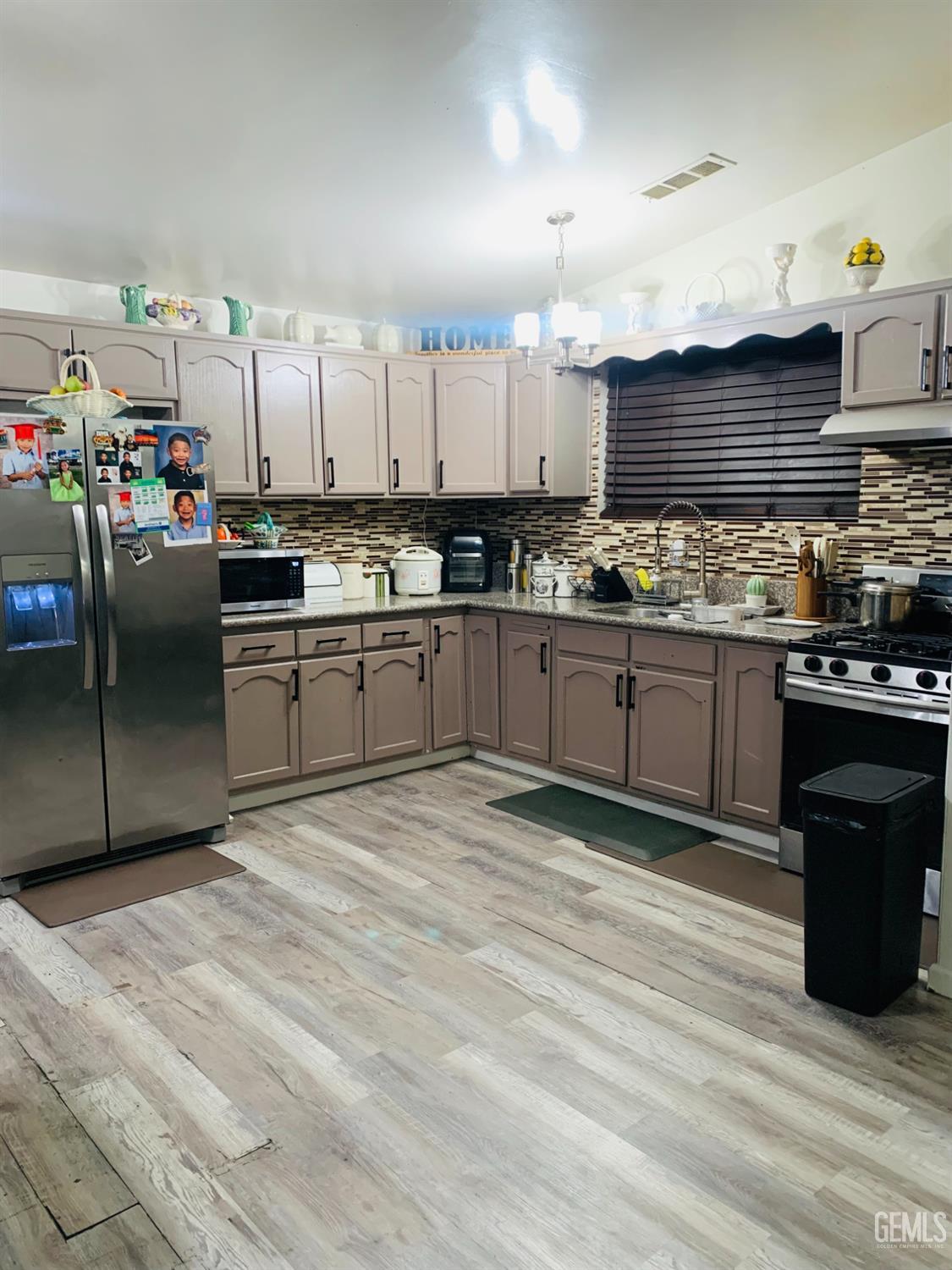 Undisclosed Address Delano, CA 93215 - Photo 7 of 14 a kitchen with stainless steel appliances granite countertop a stove a sink and a refrigerator