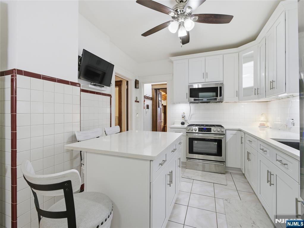 768 East 25th Street Paterson, NJ 07504 - Photo 18 of 29 a kitchen with kitchen island a sink appliances and cabinets