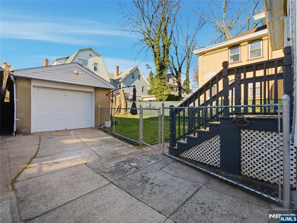 768 East 25th Street Paterson, NJ 07504 - Photo 2 of 29 a view of a brick house with a small yard and wooden fence