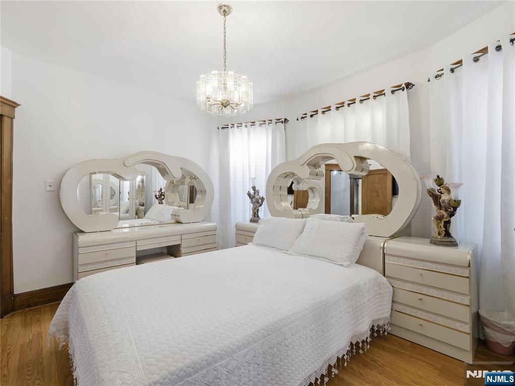 768 East 25th Street Paterson, NJ 07504 - Photo 22 of 29 a bedroom with a bed and a chandelier