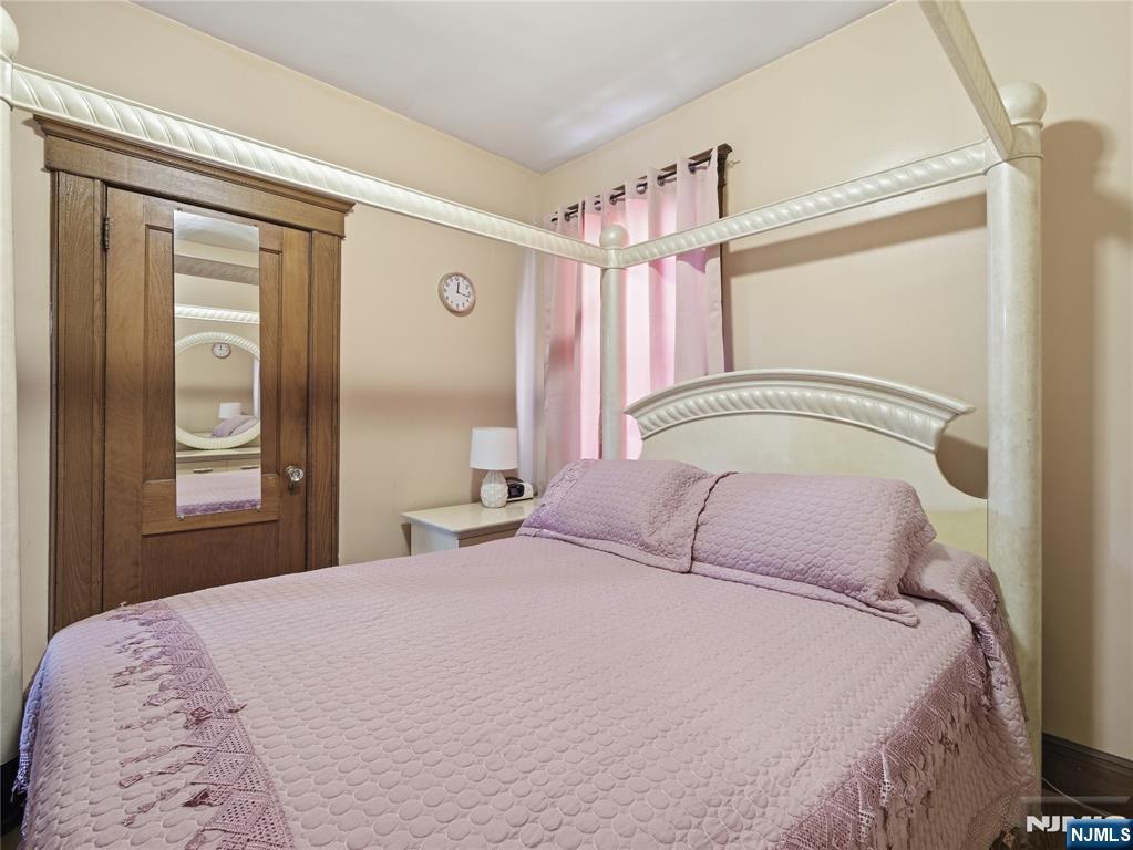 768 East 25th Street Paterson, NJ 07504 - Photo 24 of 29 a bedroom with a large bed and a chandelier