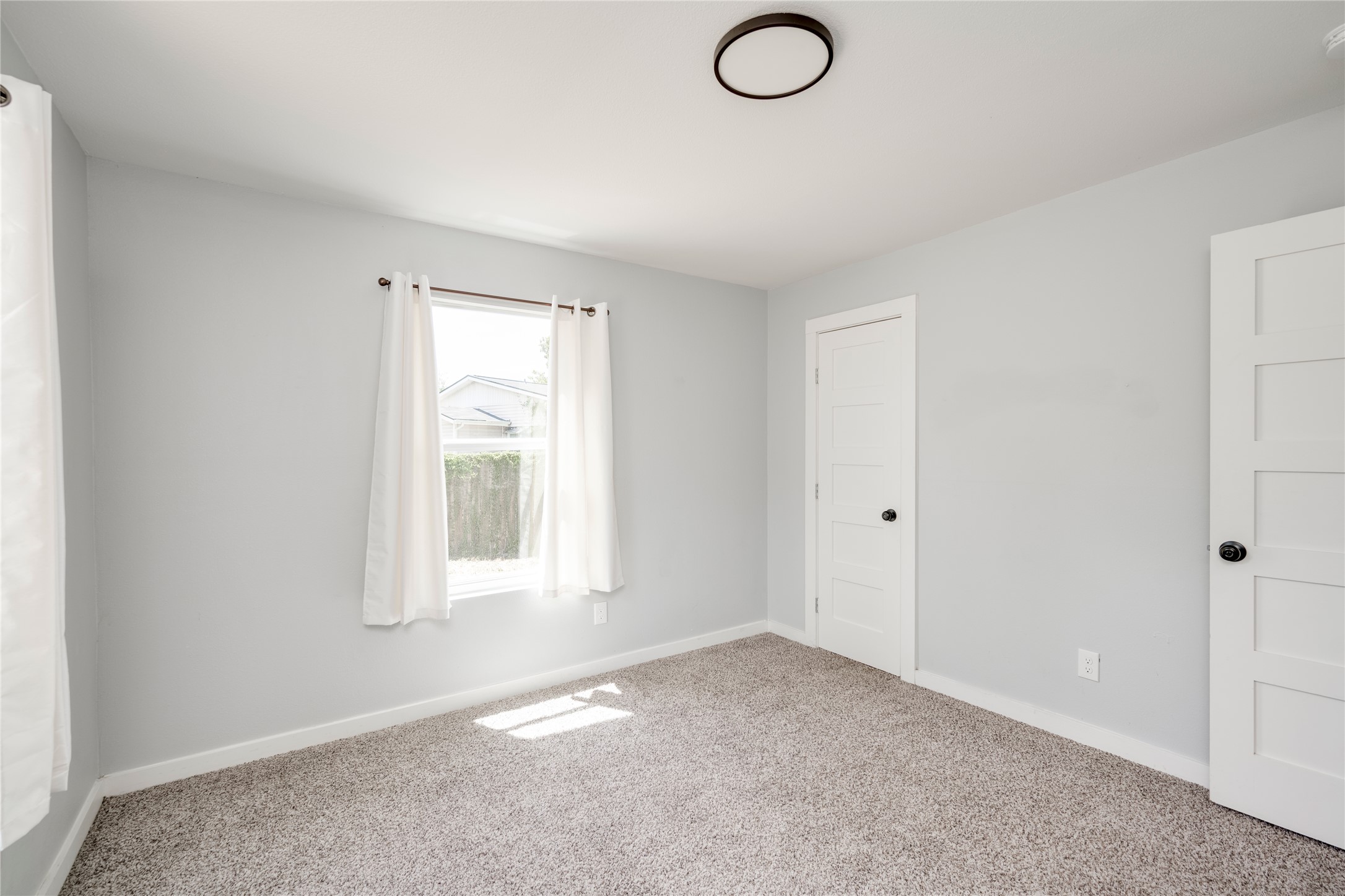 1400 Marcus Place, Unit B Austin, TX 78721 - Photo 10 of 39 A well-lit bedroom provides ample natural illumination and soft carpeted flooring.