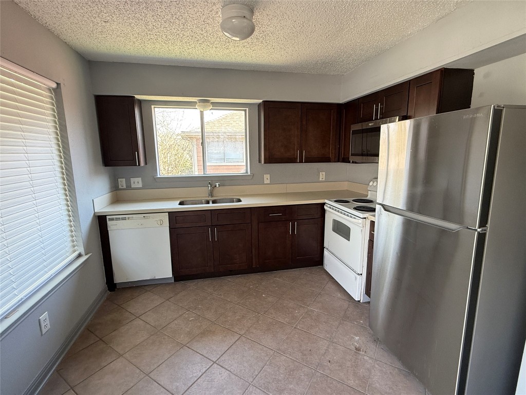 12200 Overbrook Lane, Unit 34D Houston, TX 77077 - Photo 16 of 19 a kitchen with stainless steel appliances a refrigerator a sink a stove a microwave a sink and cabinets