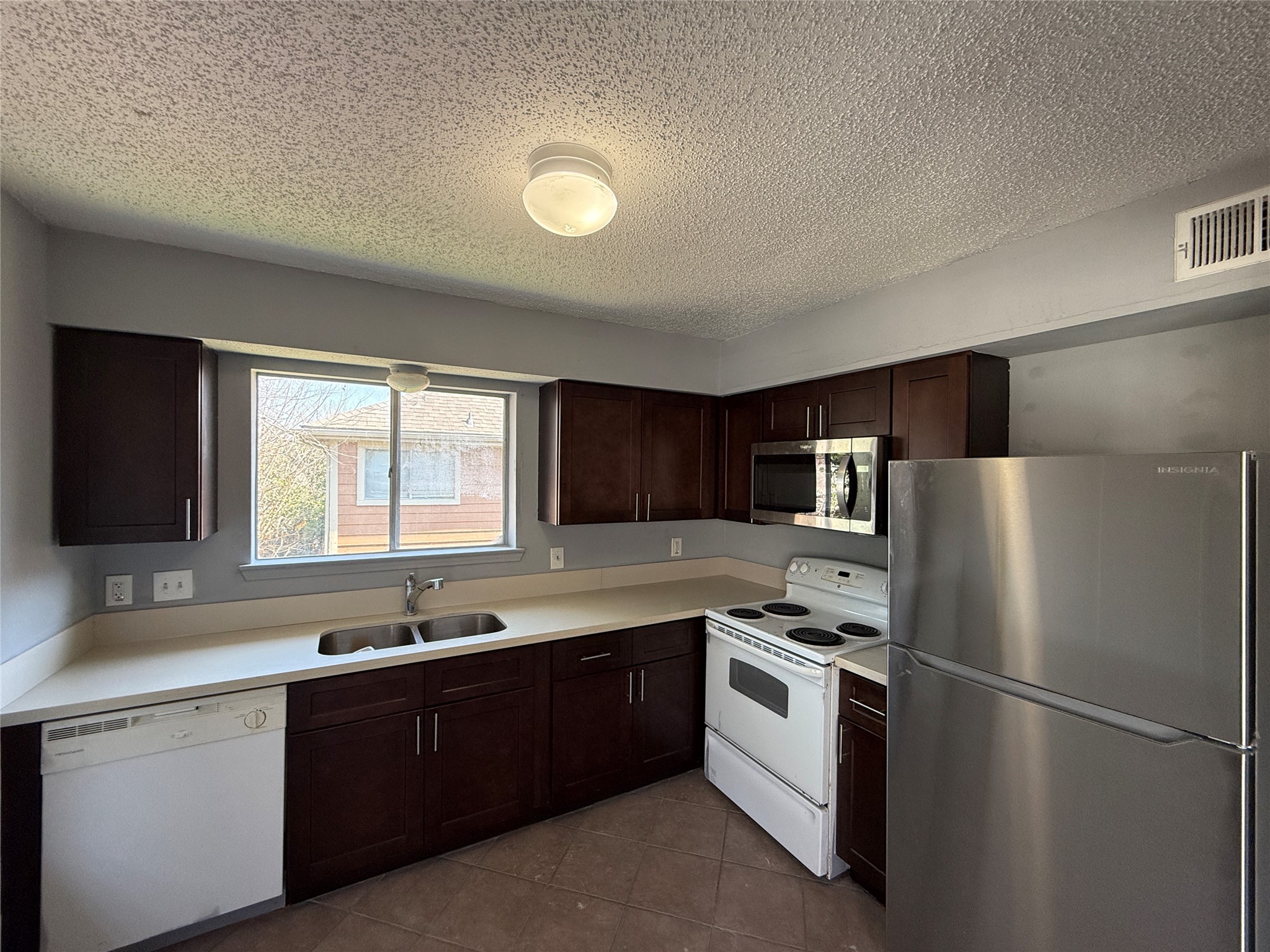 12200 Overbrook Lane, Unit 34D Houston, TX 77077 - Photo 2 of 19 a kitchen with a refrigerator sink and cabinets