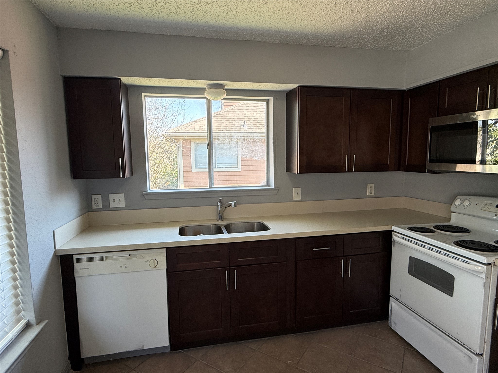 12200 Overbrook Lane, Unit 34D Houston, TX 77077 - Photo 3 of 19 a kitchen with a sink stove and microwave