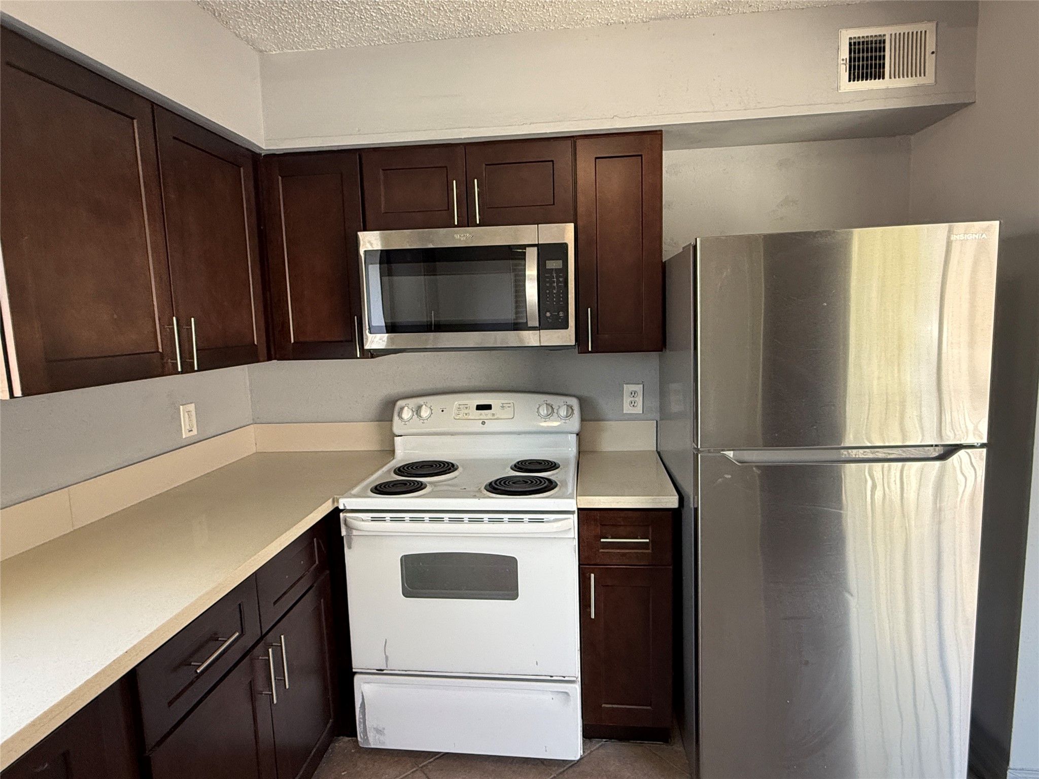12200 Overbrook Lane, Unit 34D Houston, TX 77077 - Photo 4 of 19 a kitchen with a stove microwave and refrigerator