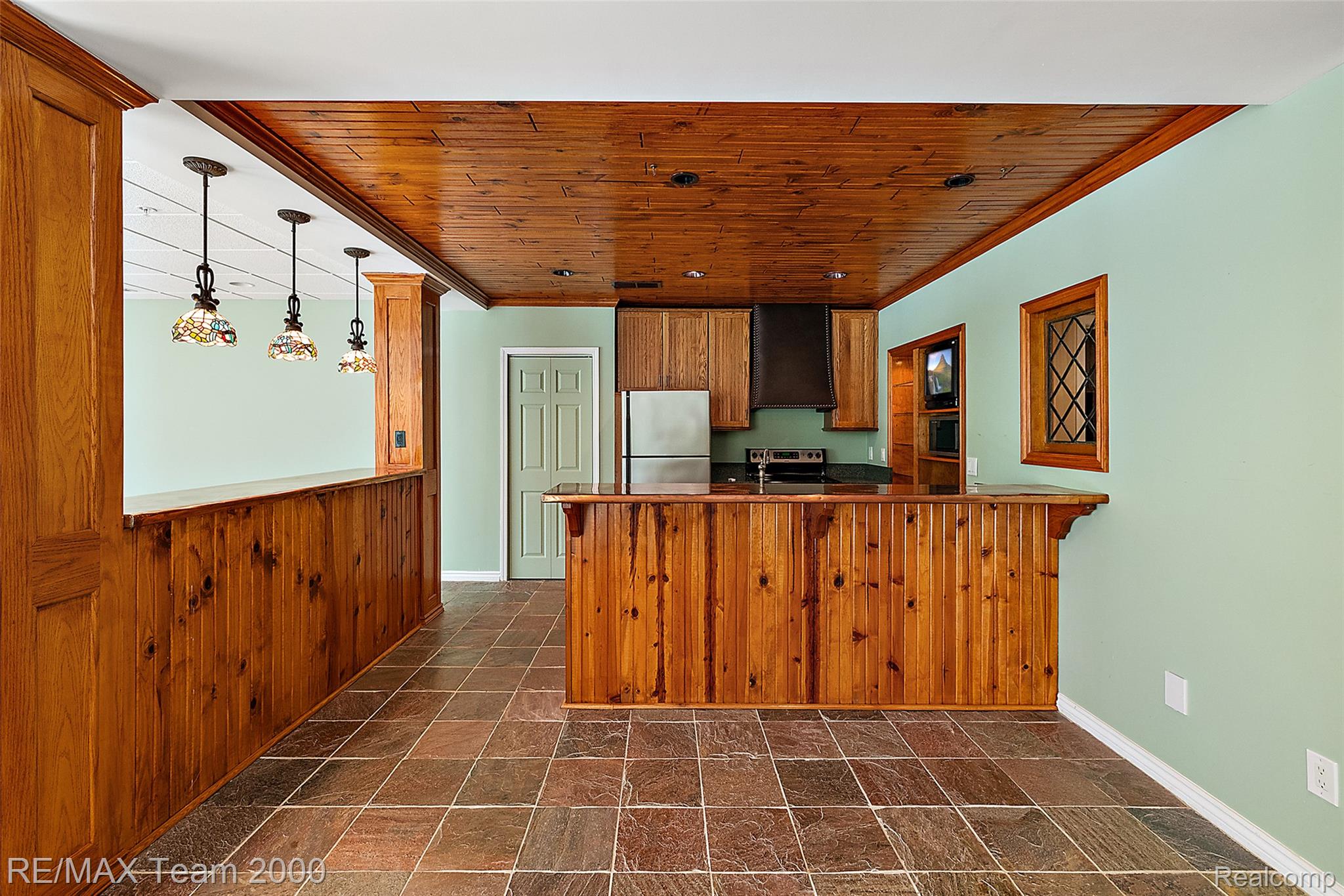 630 Sheldon Court Rochester, MI 48306 - Photo 72 of 94 Kitchen featuring wood finish cabinets, a breakfast bar, stainless steel appliances, a peninsula, and dark stone finish floors
