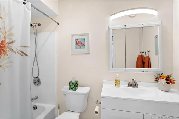 a bathroom with a sink mirror vanity and toilet