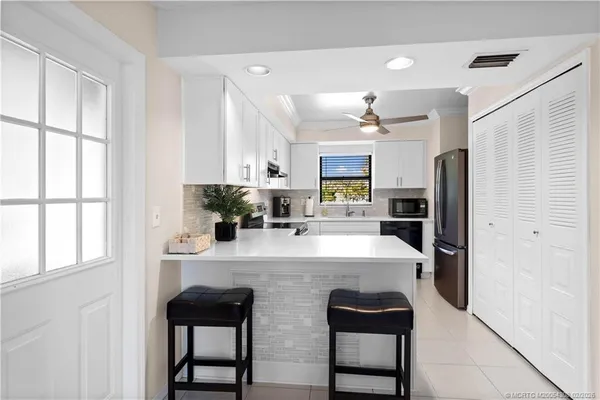 a kitchen with kitchen island a counter top space appliances and cabinets