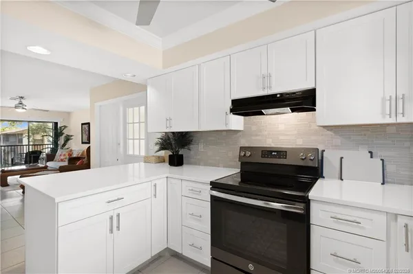 a kitchen with white cabinets and appliances