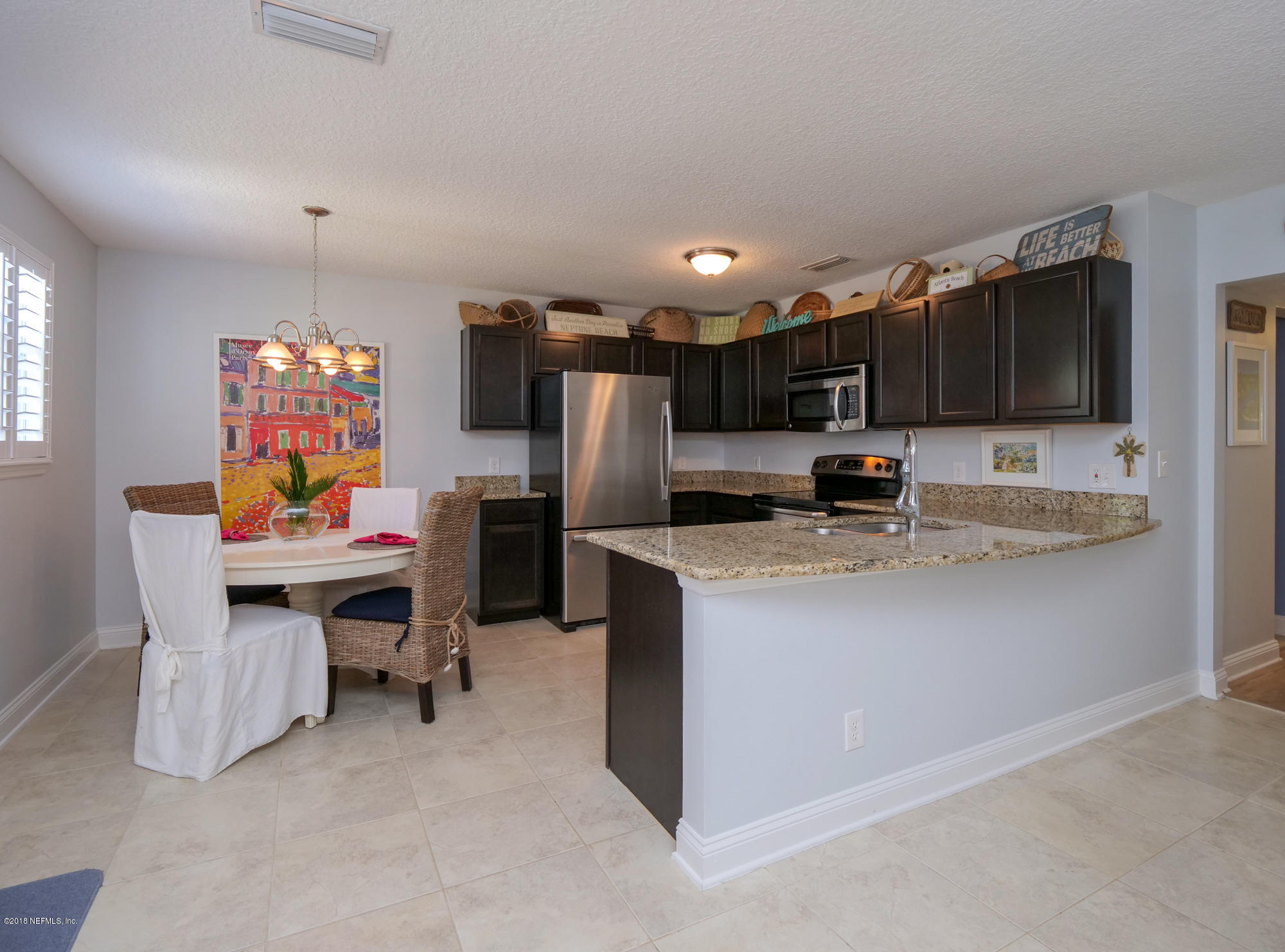 456 Irex Road Atlantic Beach, FL 32233 - Photo 29 of 29 a kitchen with stainless steel appliances kitchen island granite countertop a refrigerator and a stove top oven