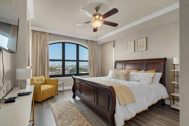 a bedroom with a bed couch and a large window