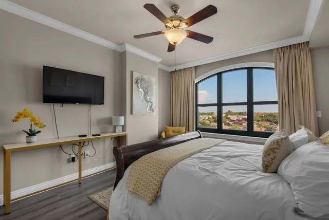 a bedroom with a bed window and a flat screen tv
