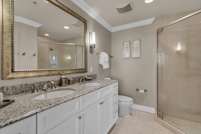 a bathroom with a granite countertop sink a toilet and a mirror