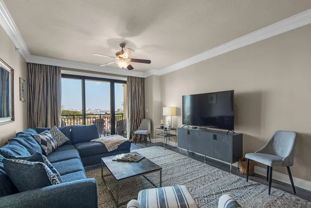 a living room with furniture a flat screen tv and a large window
