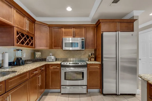 a kitchen with stainless steel appliances granite countertop a refrigerator and a stove