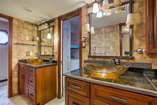 7801 Coldstream Drive Austin, TX 78748 - Photo 12 of 20 Bathroom with two vanities, tile walls, light tile patterned flooring, and decorative backsplash