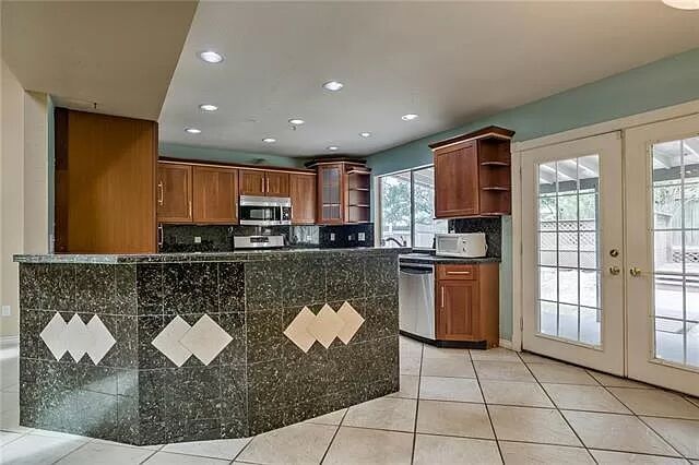 7801 Coldstream Drive Austin, TX 78748 - Photo 13 of 20 Kitchen featuring french doors, open shelves, brown cabinetry, tasteful backsplash, and recessed lighting