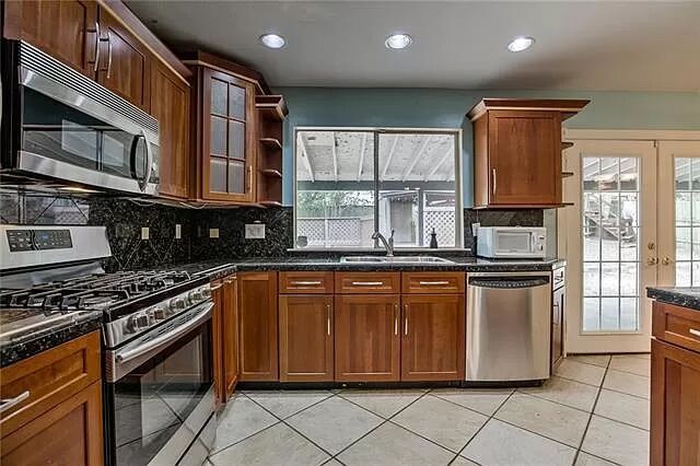 7801 Coldstream Drive Austin, TX 78748 - Photo 14 of 20 Kitchen with open shelves, stainless steel appliances, tasteful backsplash, healthy amount of natural light, and recessed lighting