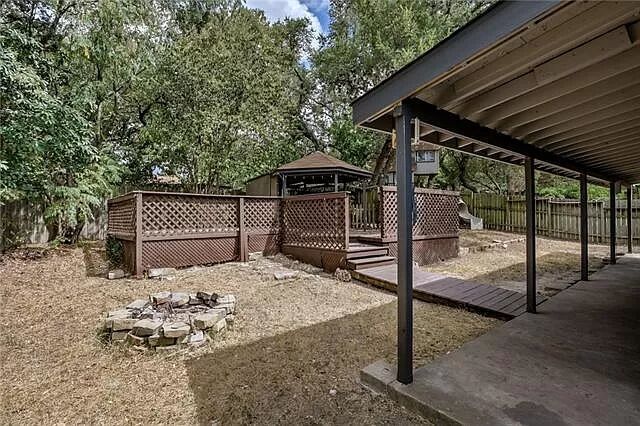7801 Coldstream Drive Austin, TX 78748 - Photo 17 of 20 Fenced backyard featuring a wooden deck, a fire pit, a gazebo, and view of scattered trees