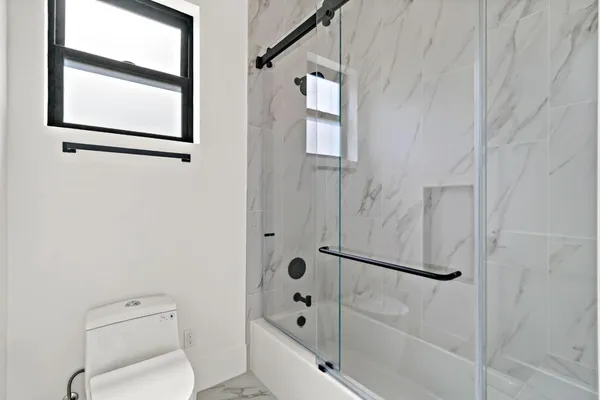 a large white kitchen with lots of counter space a sink appliances and a large window